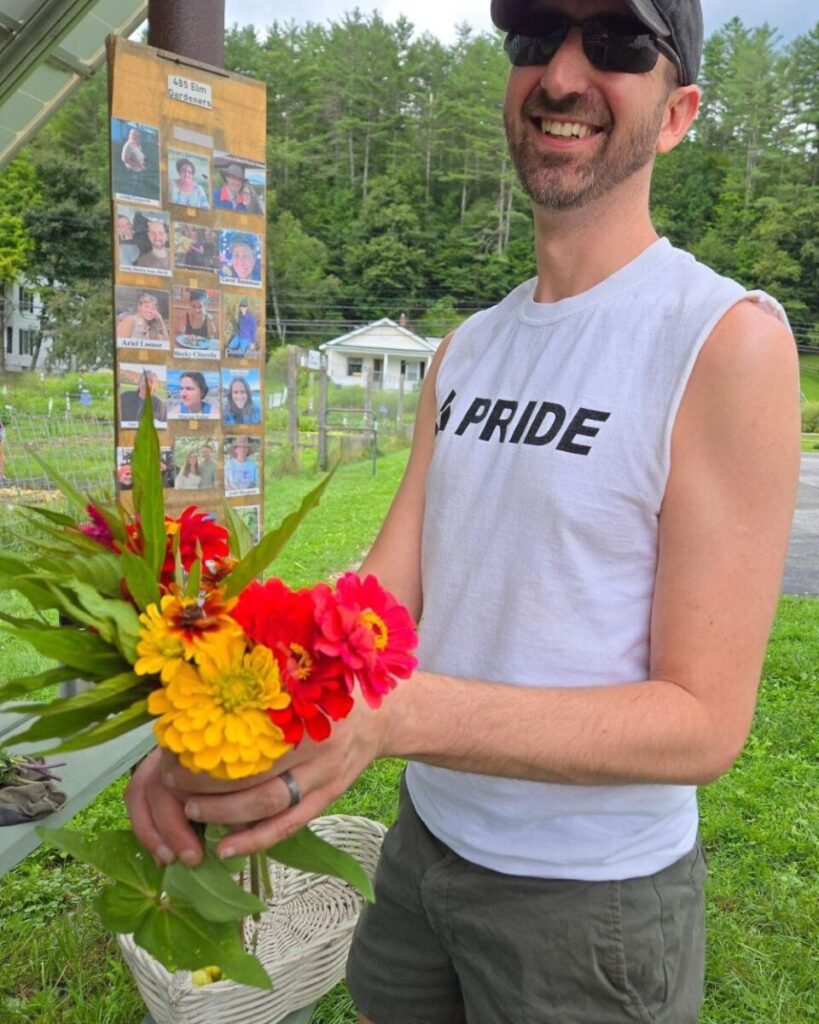 Photo shows a man outside the garden holding a bouquet