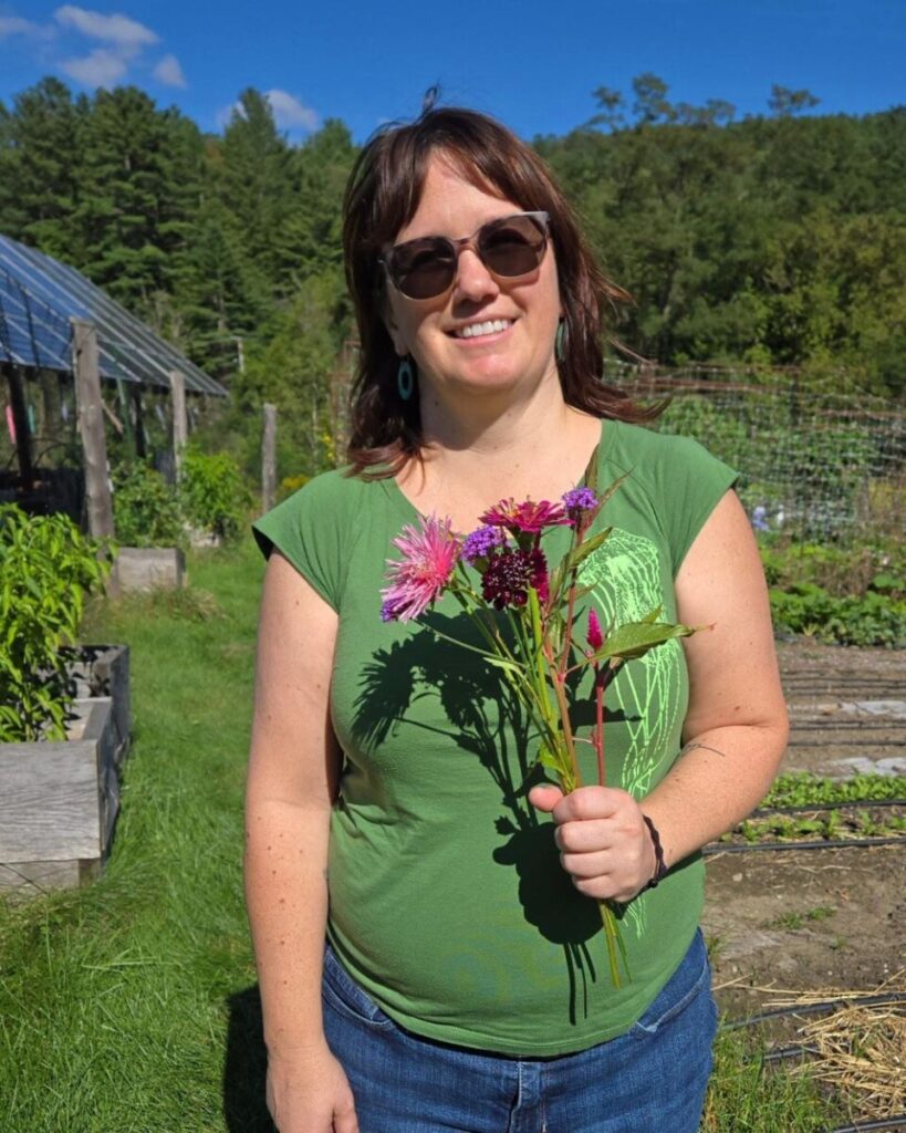 Photo shows a woman in the garden holding a bouquet